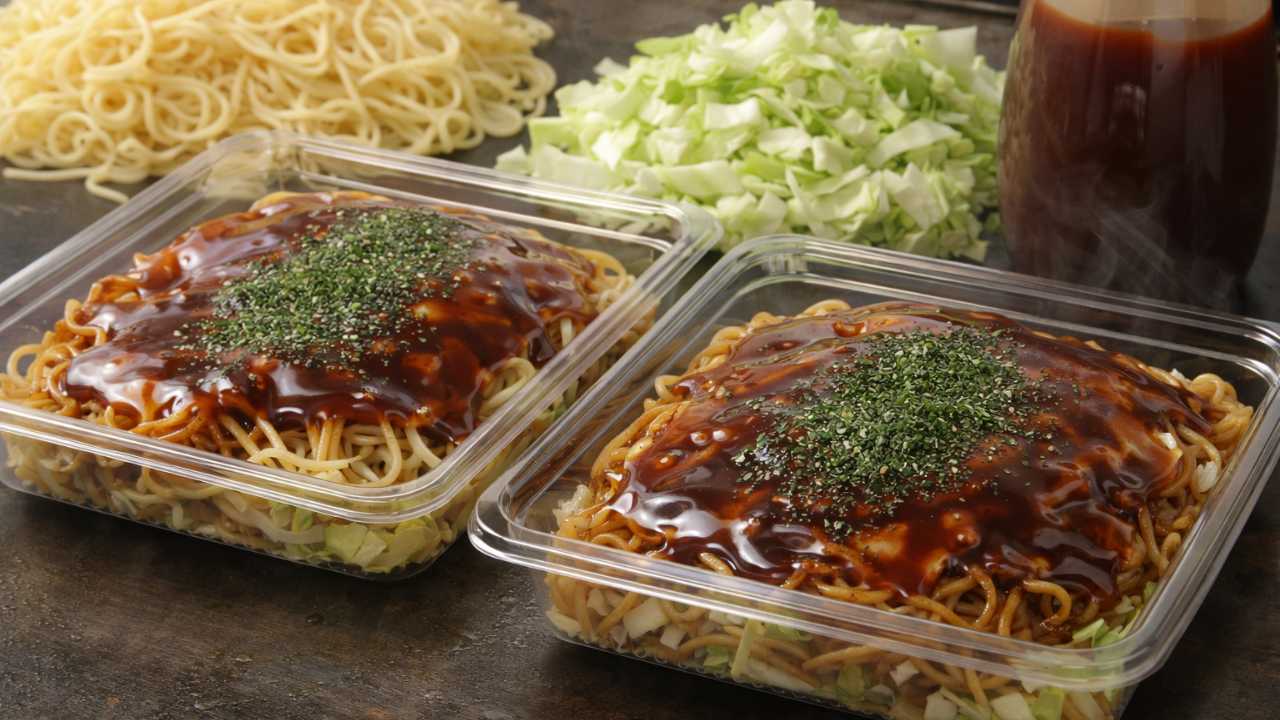 鉄板のお好み焼きを連想させる食材（ソース、麺、キャベツ）とコンビニ惣菜風の容器を並べた写真風