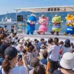 呉ご当地キャラ祭のステージイベントを楽しむ観客と、カラフルなキャラクターたちのパフォーマンス風景